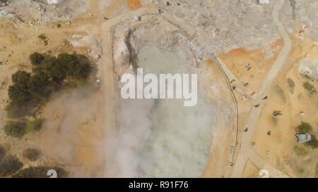 plateau with volcanic activity, mud volcano Kawah Sikidang, geothermal activity and geysers. aerial view volcanic landscape Dieng Plateau, Indonesia. Famous tourist destination of Sikidang Crater it still generates thick sulfur fumes. Stock Photo