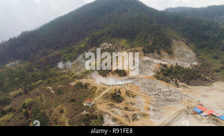 plateau with volcanic activity, mud volcano Kawah Sikidang, geothermal activity and geysers. aerial view volcanic landscape Dieng Plateau, Indonesia. Famous tourist destination of Sikidang Crater it still generates thick sulfur fumes. Stock Photo