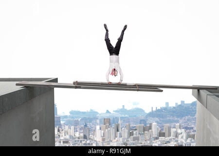 businessman up sidown on  improvised bridge between two buildings Stock Photo