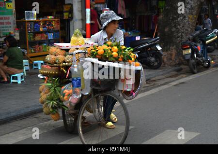 Vietnam Lady selling fruit from bicycle in Hanoi Stock Photo