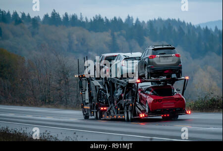 Car transportation by big rig semi truck allows all dealerships to ensure uninterrupted sale of new and used cars ensuring consumer demand in any stat Stock Photo