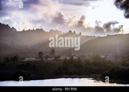 Rays of light illuminating the hills surrounding Crystal Springs Reservoir, San Francisco bay area, California Stock Photo