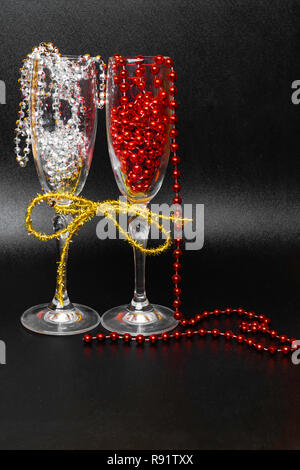 two glasses on celebratory table, decorated with gold ribbon, garlands Stock Photo