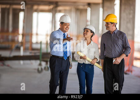 An architect and two executives talk on construction site. Stock Photo