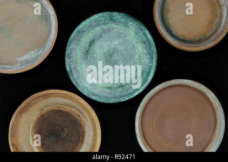 Background surface of various colors and dirty clay plates for plants and isolated on black background Stock Photo