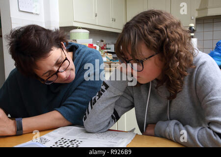 Mother and 12 Year old Daughter working on Crossword Puzzle Together Surrey England Stock Photo
