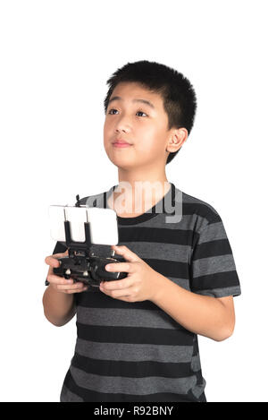 Asian boy holding radio remote control (controlling handset) for helicopter, drone or plane, studio shot isolated on white background. with clipping p Stock Photo