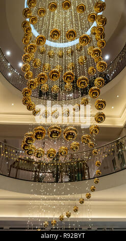 Cascade of shiny, reflective gold baubles in the stairwell of the historic Fortnum and Mason store in central London, England, UK Stock Photo