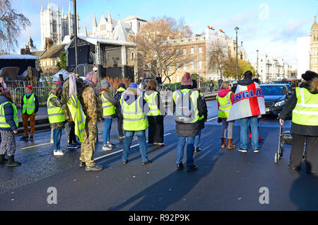 London, 19th December 2018. Pro Brexit supporters (who last week blocked Westminster Bridge) stop the traffic outside Parliament for a few minutes before being moved to the pavement by the police. Credit: PjrFoto/Alamy Live News Stock Photo
