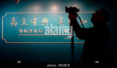 Beijing, China. 19th Dec, 2018. A visitor shoots at an exhibition in commemoration of the 120th anniversay of Zheng Zhenduo's (1898-1958) birth at National Museum of Classic Books in Beijing, capital of China, Dec. 19, 2018. More than 70 pieces of Zheng's personal belongings and collections are on display. Zheng Zhenduo was a Chinese journalist, writer, archaeologist and scholar. Credit: Yin Gang/Xinhua/Alamy Live News Stock Photo