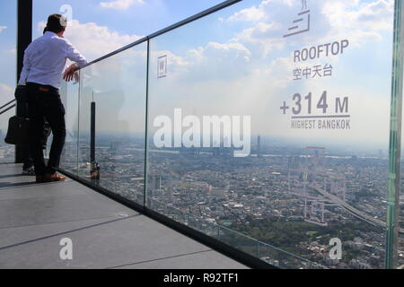 Bangkok, Bangkok, Thailand. 21st Nov, 2018. Two men seen leaning against a glass barrier on the higher rooftop of Bangkok.In November 2018, Mahanakhon Tower opened a rooftop featuring a glass sky walk of 314 meters height. It is today the highest observation point of Bangkok. Credit: Thibaud Mougin/SOPA Images/ZUMA Wire/Alamy Live News Stock Photo