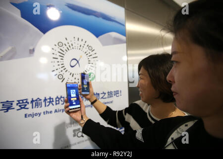 Athens, Greece. 19th Dec, 2018. People scan the QR code to get access to the application 'AIA - Toorbee WeChat Miniapp' at Athens International Airport in Athens, Greece, on Dec. 19, 2018. Athens International Airport presented on Wednesday here an application for mobile devices especially designed for the Chinese travellers, aiming to further facilitate their stay at the airport and the Greek capital. Credit: Marios Lolos/Xinhua/Alamy Live News Stock Photo