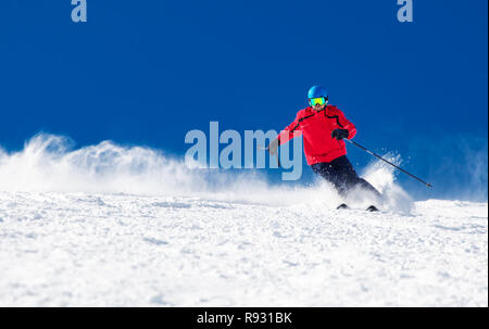 Man skiing on the prepared slope with fresh new powder snow. Stock Photo