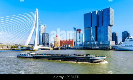 Rhine Barge on the Nieuwe Maas with the Erasmus Bridge and modern High Rise buildings at the Holland Amerikakade cruise terminal in Rotterdam, Holland Stock Photo