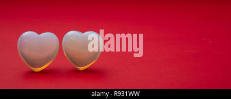 Valentines day. Top view of light blue glass hearts on red background, banner, copy space Stock Photo