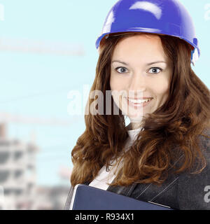 Smiling woman architect working on the background of construction Stock Photo
