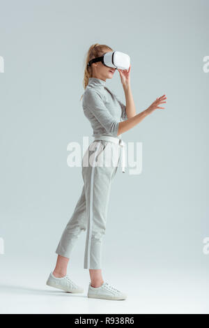 girl in grey clothing gesturing on grey background Stock Photo