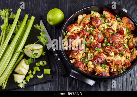 classic version of thanksgiving or christmas Stuffing with crisp, browned top, made with bread, celery, onions, apples, chestnuts and herbs in a black Stock Photo