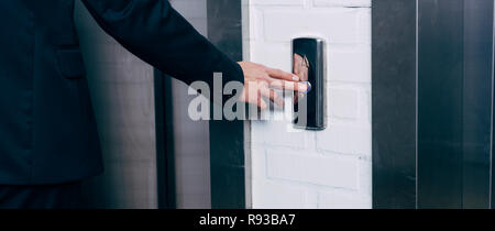 cropped view of man pressing elevator button Stock Photo