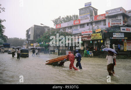 Heavy rain in Mumbai, monsoon rain floods, flooded street, pushing hand cart, Bombay, Mumbai, Maharashtra, India, Asia Stock Photo