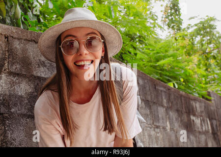 Attractive smiling young woman in eyeglasses near plants Stock Photo