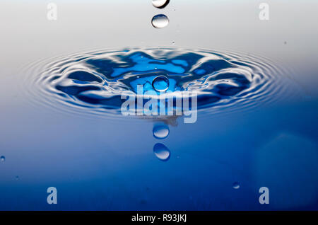 Blue water droplet making a splash Stock Photo