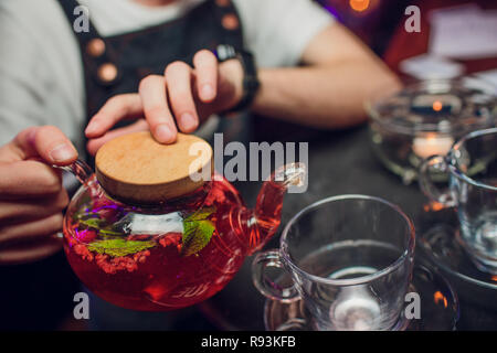 Still life with beautiful worn retro style copper tea kettle with three empty glasses on massive wooden table. Stock Photo