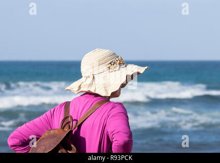 Rear view of mature woman on holiday looking out over the sea Stock Photo