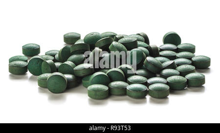 Close up of organic spirulina tablets over white background. Stock Photo