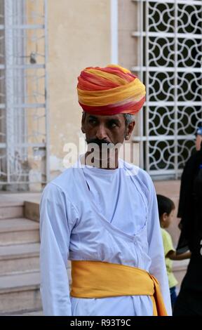An Indian man in white with orange and yellow turban Stock Photo