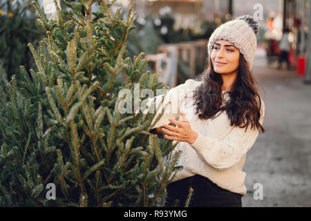 Cute brunette in a white sweater with Christmas tree Stock Photo