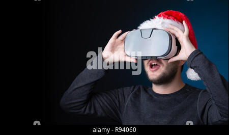 Picture of man in Santa's cap and glasses of virtual reality Stock Photo