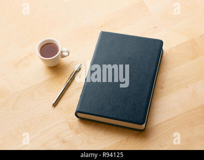 books, pencils, and coffee on the wooden desk. Stock Photo