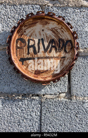informative sign on rusty paint cover, private word in spanish Stock Photo