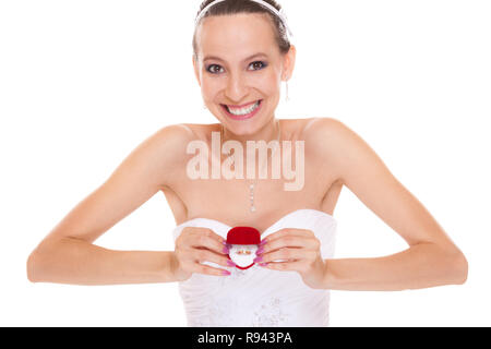 Excited happy bride holding showing engagement ring box. Surprised woman in white wedding dress isolated on white background. Stock Photo