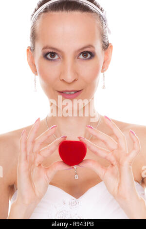 Excited happy bride holding showing engagement ring box. Surprised woman in white wedding dress isolated on white background. Stock Photo