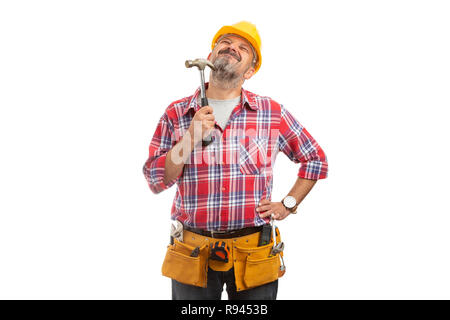 Builder having pleased expression scratching chin with facial hair by using hammer isolated on white background Stock Photo
