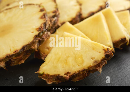Sliced fresh pineapple on a slate surface Stock Photo