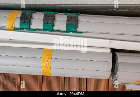 Rolled up metal shutters ready for window installation Stock Photo