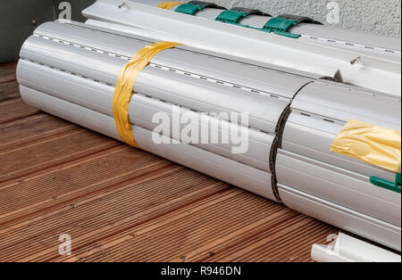 Rolled up metal shutters ready for window installation Stock Photo