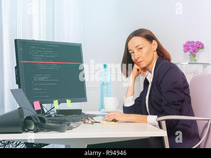Portrait of middle aged sad business woman working on the computer in the office Stock Photo