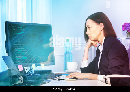 Side view portrait of upset businesswoman looking at the screen of computer, working in her office Stock Photo