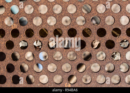 detail of perforated and rusty metal, rusty and leaky metal plate, metal corroded texture, rusty metal background, brown Stock Photo