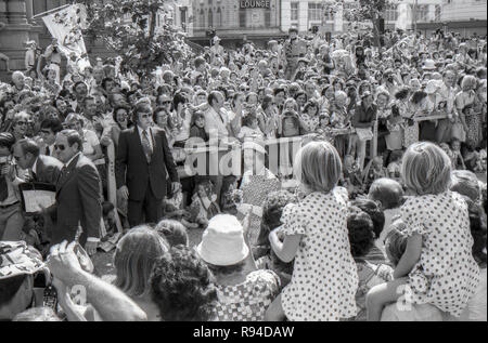 Sydney Australia, March 13th 1977: Crowds of people of all ages line barricades and wave and cheer at the arrival of Queen Elizabeth II and Prince Philip at Sydney Square near the Town Hall. The Royal couple  attended a civic reception with the Lord Mayor, Leo Port  and later a service at the nearby St Andrews Cathedral. Her Majesty and the Prince were visiting Sydney along with numerous other parts of Australia during March as part of their Silver Jubilee world tour. Photo credit Stephen Dwyer (Aged 17) Stock Photo