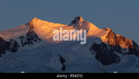 Last sunlight on the Dufourspitze and the Monte Rosa massif, seen from the famous Gornergrat.  Zermatt, Switzerland. Stock Photo