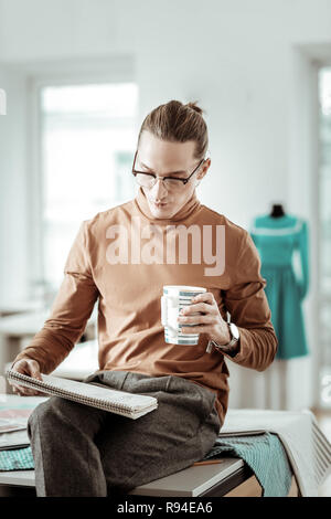 Young long-haired designer from generation Y thinking about new models Stock Photo