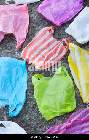 Colorful plastic bags on cement floor background. Stock Photo