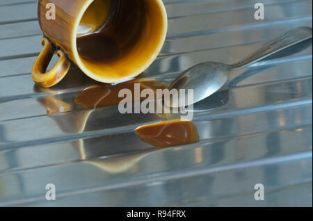 overturned coffee cup and spoon on kitchen sink Stock Photo