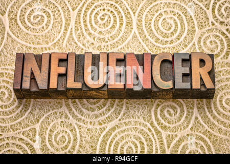 influencer - word abstract in vintage letterpress wood type against Japanese washi paper with a spiral pattern Stock Photo