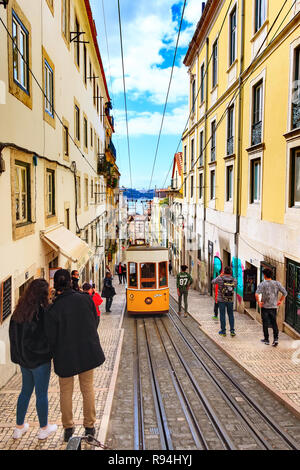 Lisbon, Portugal - March 29, 2018: People waiting for yellow funicular tram tram, symbol of Lisbon and downtown street Stock Photo
